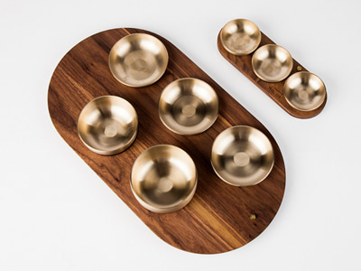 Walnut tray of brass tableware